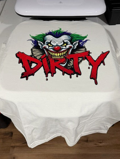 White t-shirt with a graphic design and the word 'DIRTY' on a table.